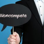 Noncompete. Businessman (Man) is holding the sign of speech bubble in his hand. Handwritten Text on the Label. Business, Finance, Analysis, Economy