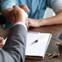 Estate agent shaking hands with his customer after contract signature Estate agent shaking hands with his customer after contract signature