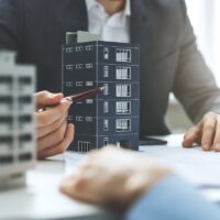 real estate developer and architect discussing new housing development project in office real estate developer and architect discussing new housing development project in office